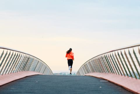 Woman Running Along a Path in the morning Woman Running Along a Path in the morning